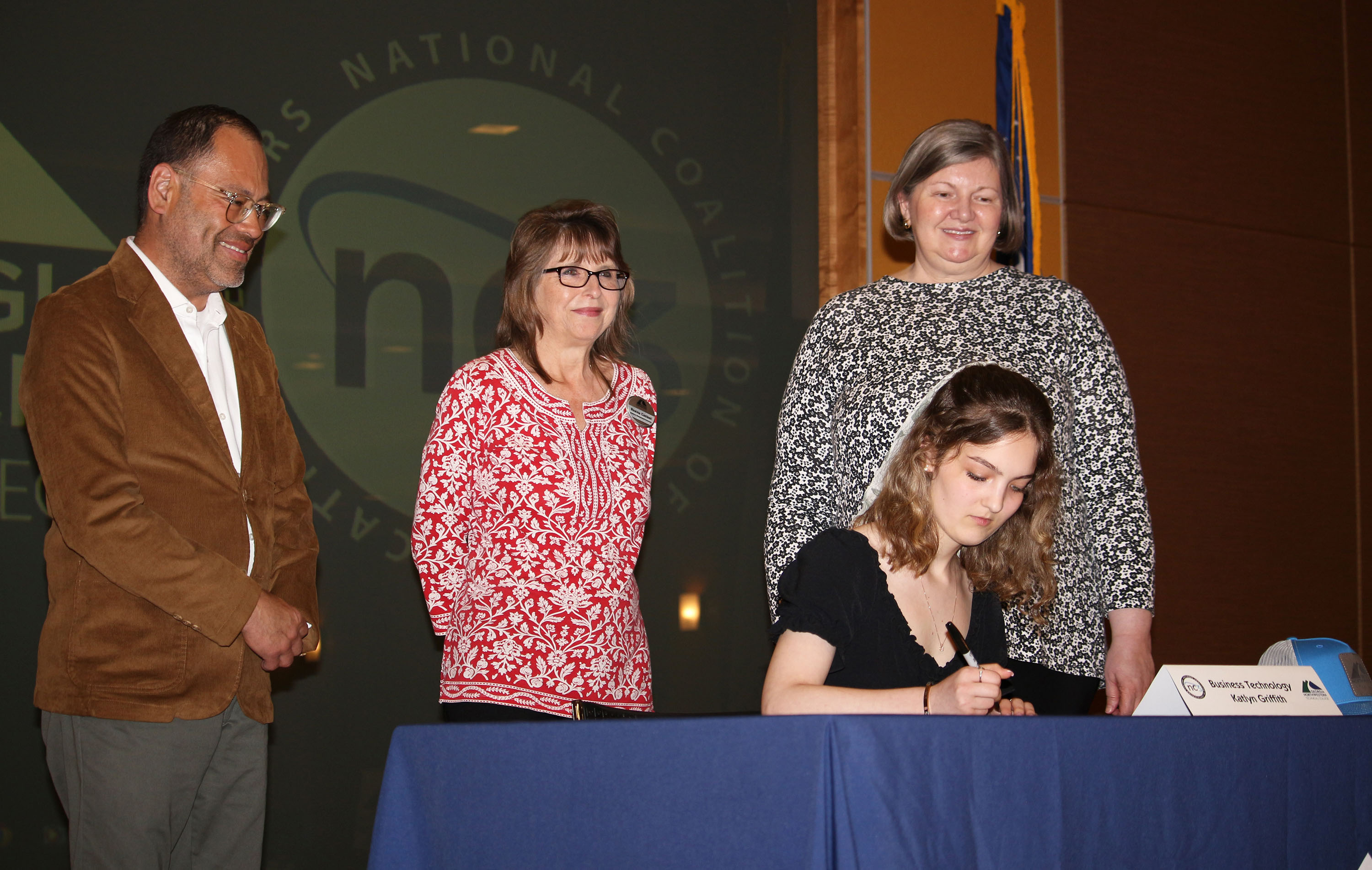 Katlyn Griffith signs her Letter of Intent to study Business Technology as app instructors (from left) Leyner Argueta, director and instructor of Business Management; Regina Casteel, instructor of Business Management; and Lisa Hunt, director of Business Healthcare Technology, look on.